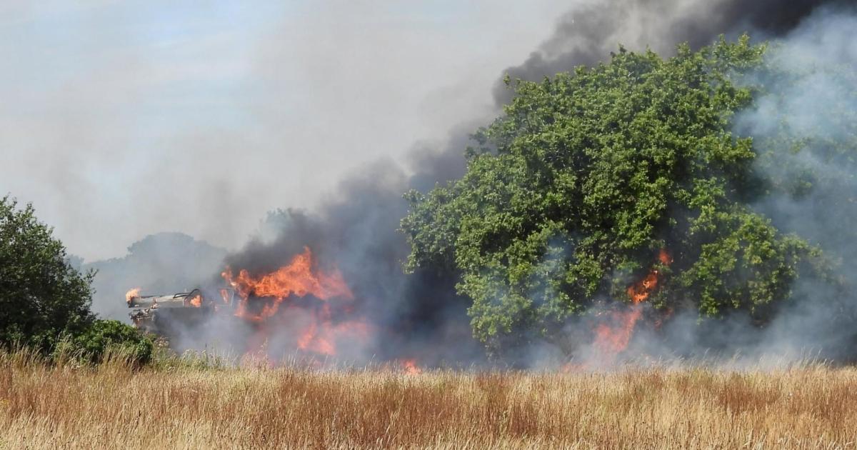 Dramatic photos show field fire that engulfed combine harvester