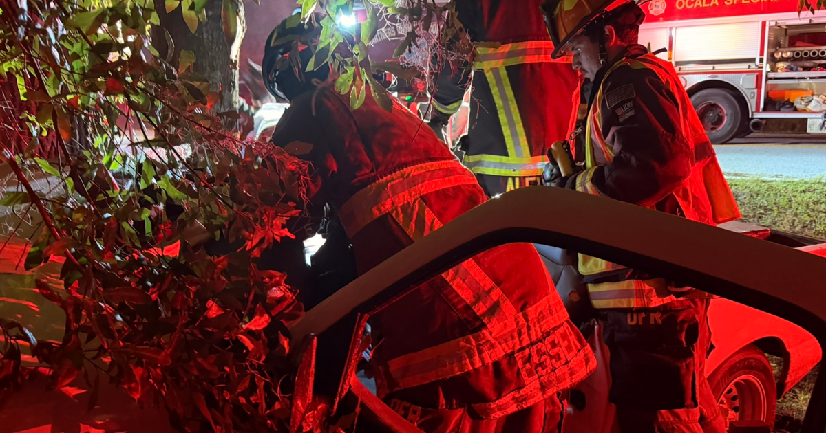 Fire crews free 2 people trapped in pickup truck after crash, wedged between fence, tree