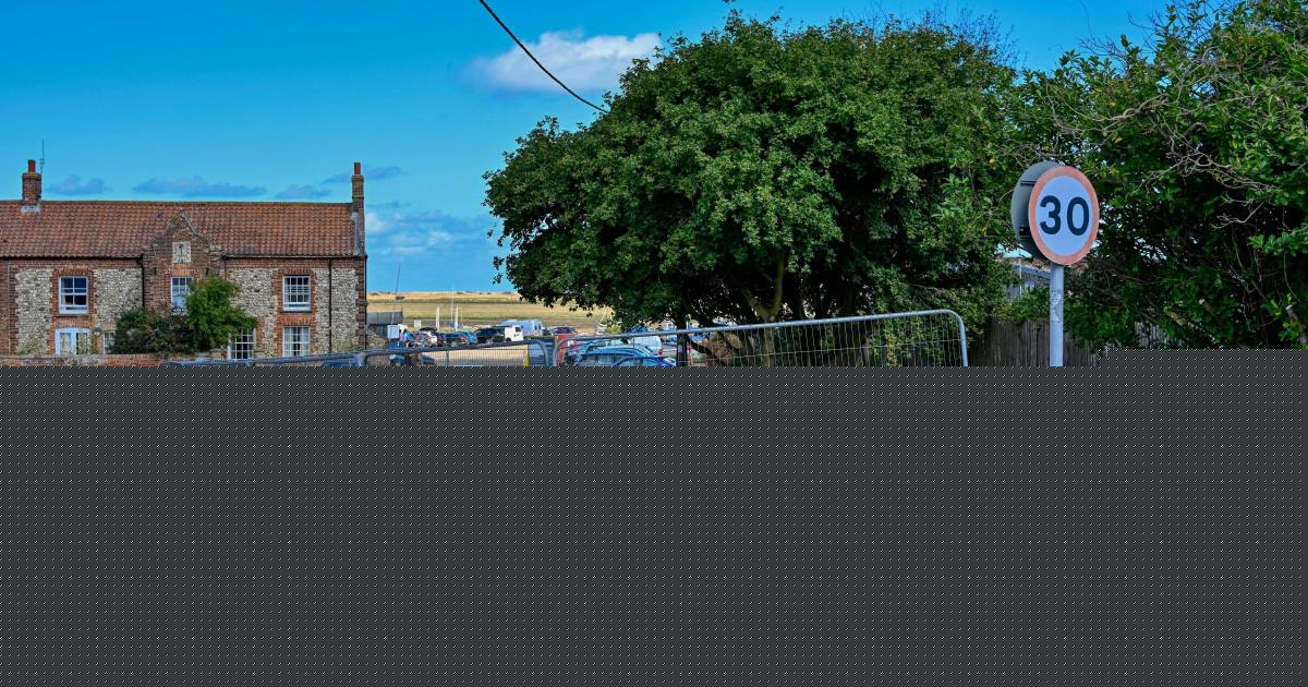 Village green fenced off after parking row at harbour