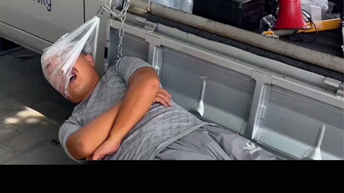 Street vendor's unique bed made from two stools and a plastic bag pillow hammock