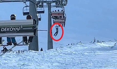 Düşen snowboardını almak için atlamaya çalıştığı telesiyejde asılı kaldı
