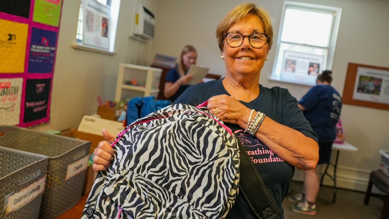 Volunteers pack book bags full of school supplies for families dealing with cancer