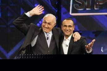 Baudo, Conti ricorda il grande conduttore: “Lui è la tv, indimenticabili i suoi abbracci paterni”