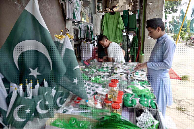 Seasonal vendors display national flags and Independence Day-themed items at a roadside stall in Aabpara Market ahead of August 14 celebrations.