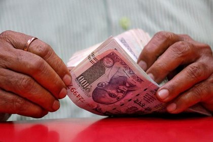 Rupee hits record low, RBI intervention averts fall past 92